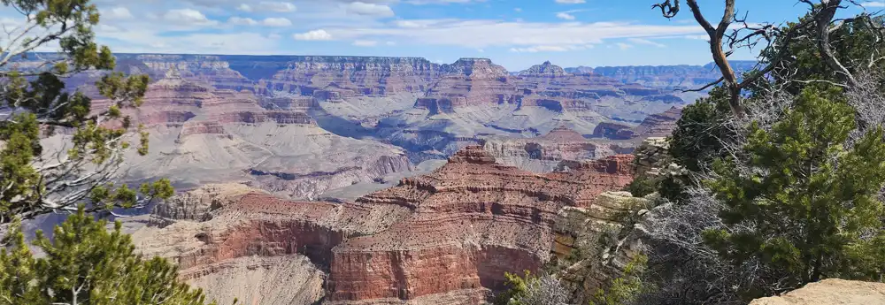 Grand Canyon landscape with layered rock formations under a vibrant blue sky
