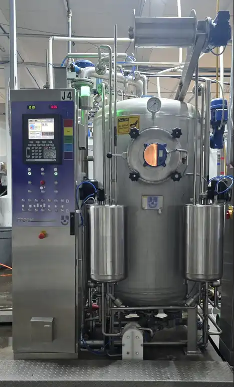 Person operating machines where fabrics are being dyed purple, brown, grey, pink, and yellow