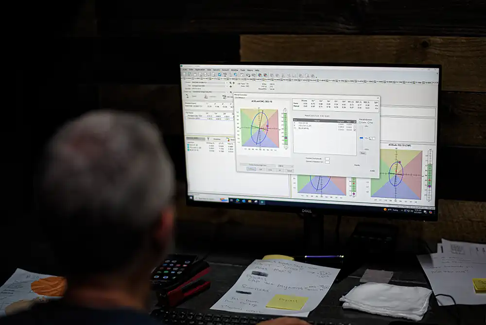 Technician using **Pantone Matching System (PMS)** for lab dips